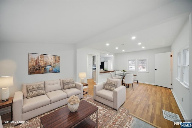 living area featuring recessed lighting, visible vents, baseboards, and light wood-style flooring