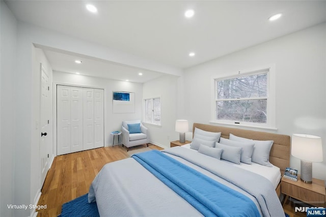 bedroom featuring a closet, recessed lighting, light wood-type flooring, and baseboards