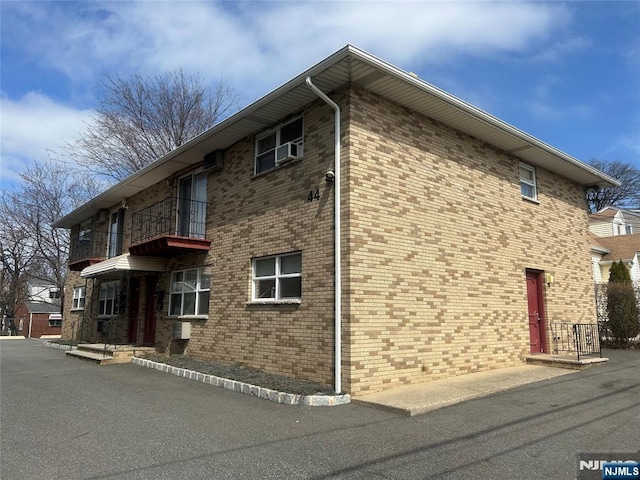 view of property exterior with a balcony and brick siding