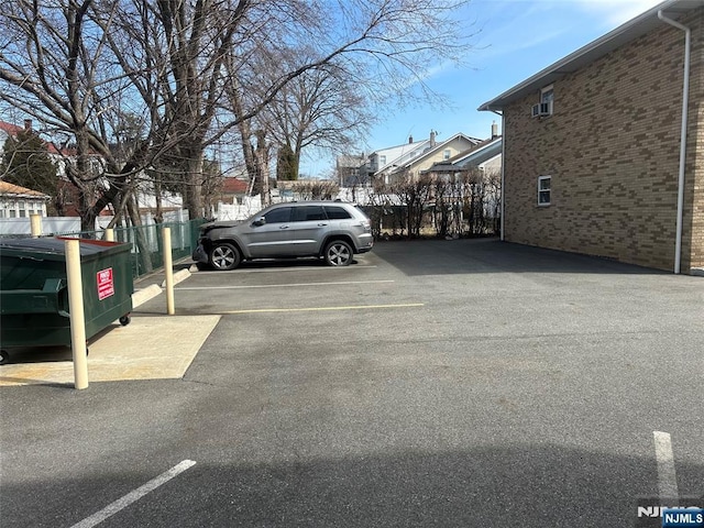 uncovered parking lot featuring fence