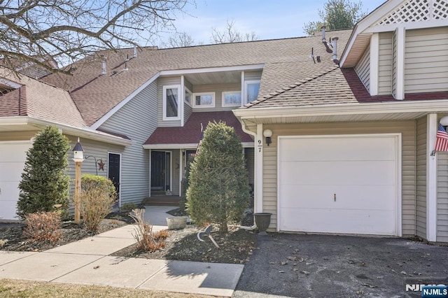 view of front of property with driveway, a shingled roof, and an attached garage