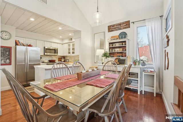 dining space featuring recessed lighting, wood-type flooring, baseboards, and vaulted ceiling