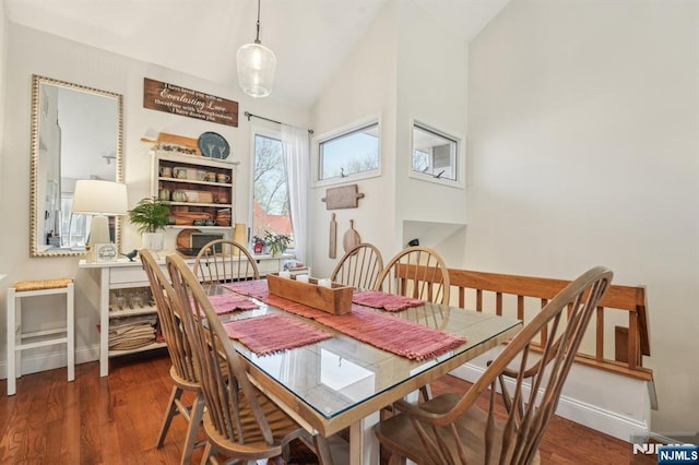 dining room featuring vaulted ceiling, wood finished floors, and baseboards