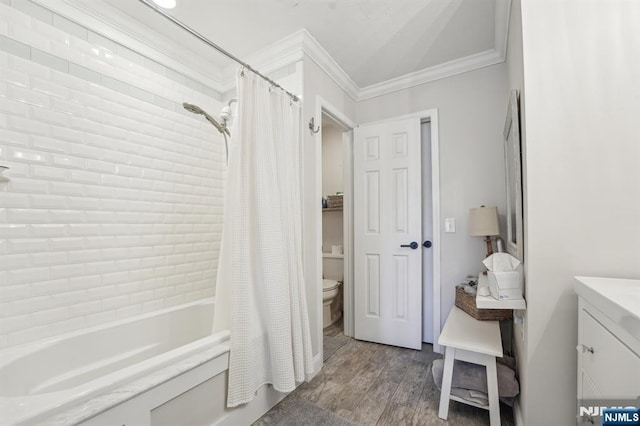 bathroom featuring crown molding, toilet, wood finished floors, vanity, and shower / bathtub combination with curtain