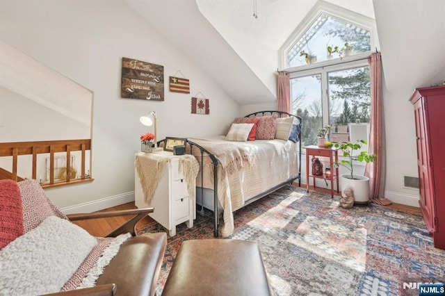 bedroom featuring wood finished floors, baseboards, and vaulted ceiling