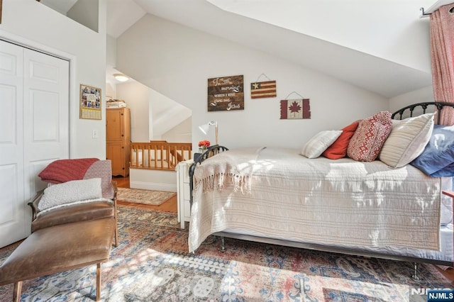 bedroom featuring lofted ceiling, wood finished floors, and a closet