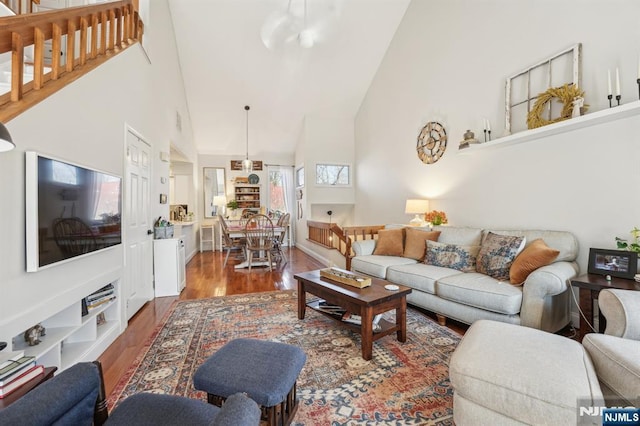 living area featuring wood finished floors and high vaulted ceiling