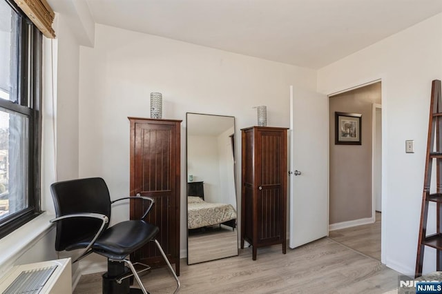 living area featuring baseboards and light wood-type flooring