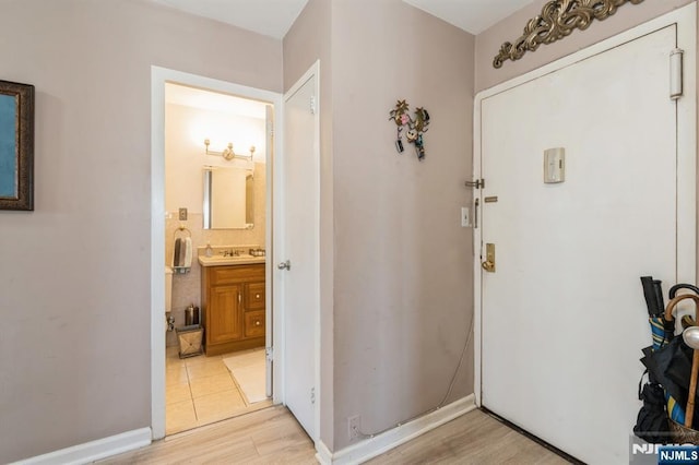 entrance foyer with baseboards and light wood-style floors