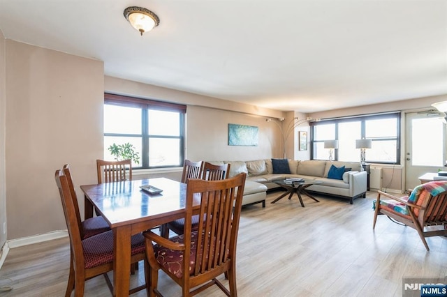 dining room featuring light wood finished floors and baseboards