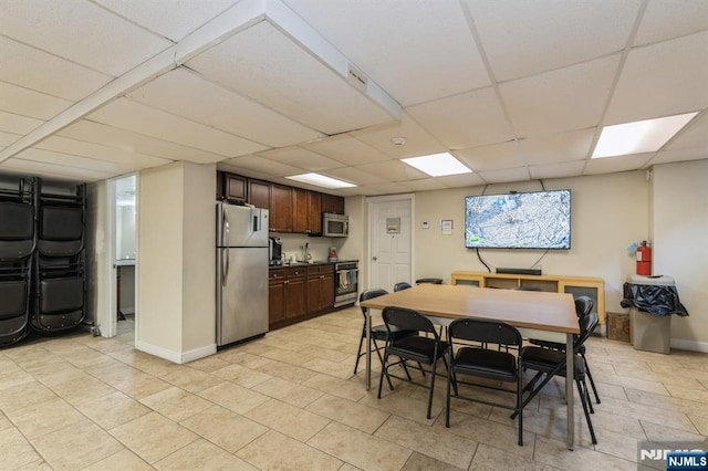 dining area with baseboards and a paneled ceiling