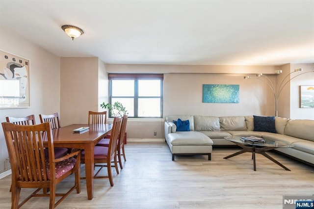 dining space featuring baseboards and light wood-type flooring