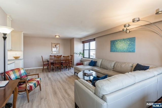 living room with light wood-style flooring and baseboards