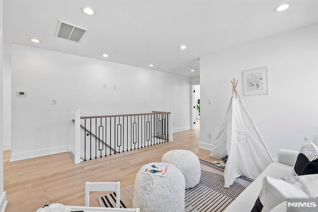 interior space featuring visible vents, light wood finished floors, baseboards, attic access, and recessed lighting