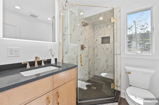 full bath with a marble finish shower, visible vents, toilet, recessed lighting, and vanity