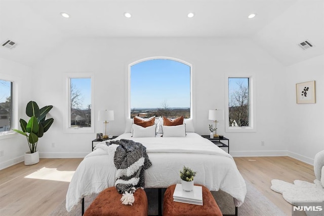 bedroom with lofted ceiling, multiple windows, and visible vents