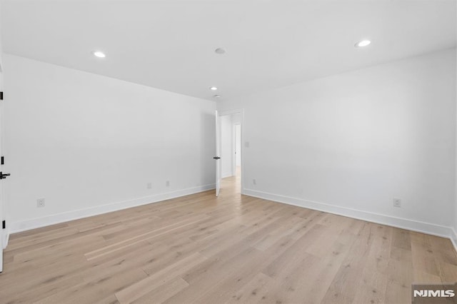 spare room featuring recessed lighting, light wood-style flooring, and baseboards