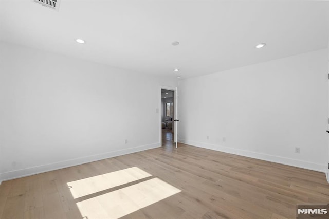 spare room featuring recessed lighting, light wood-style flooring, visible vents, and baseboards