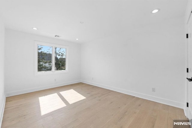 empty room featuring recessed lighting, baseboards, visible vents, and light wood finished floors