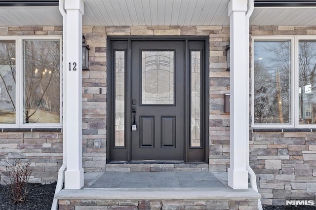 property entrance featuring stone siding and a porch