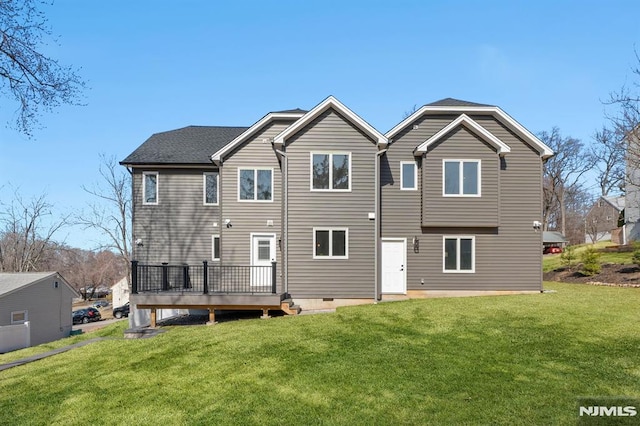 rear view of house with a lawn and a wooden deck