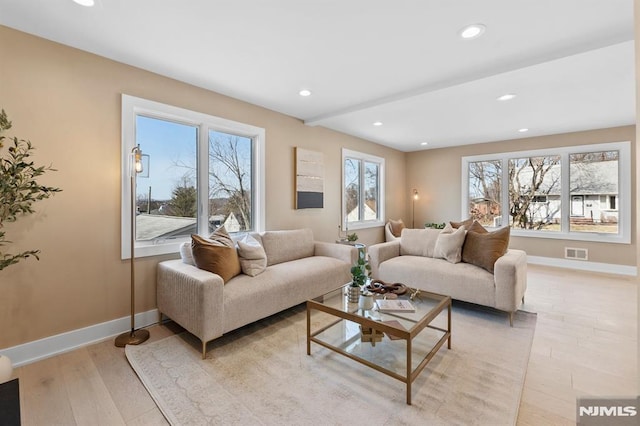 living area with recessed lighting, visible vents, baseboards, and light wood-style flooring