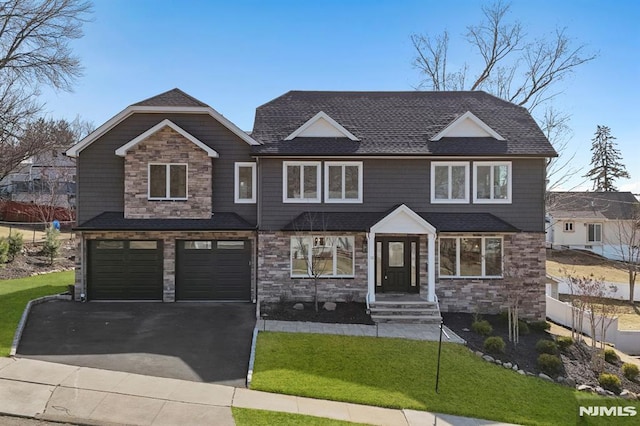 view of front of property with a front lawn, a garage, fence, and stone siding