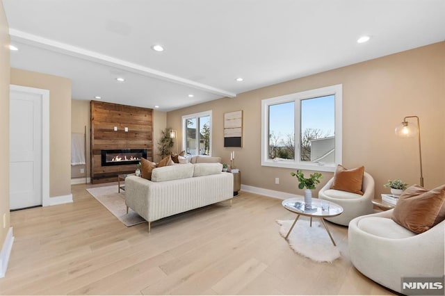 living room with recessed lighting, light wood-style floors, baseboards, and a large fireplace