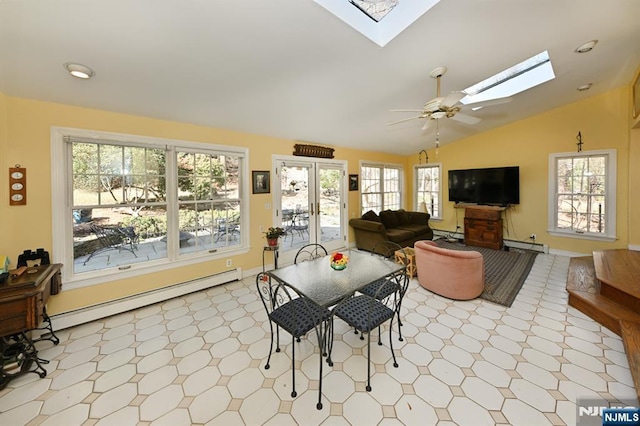 dining area featuring ceiling fan, lofted ceiling with skylight, baseboards, and a baseboard radiator