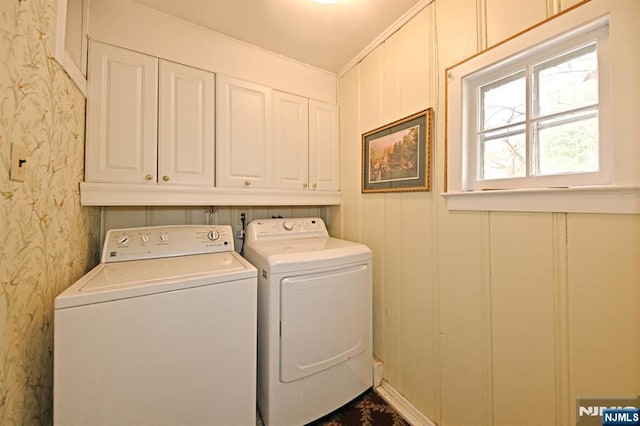 washroom with wallpapered walls, cabinet space, and independent washer and dryer