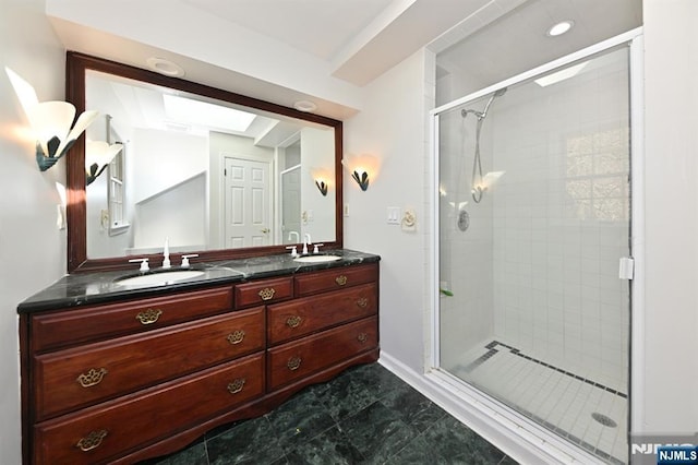 full bathroom featuring a shower stall, double vanity, and a sink