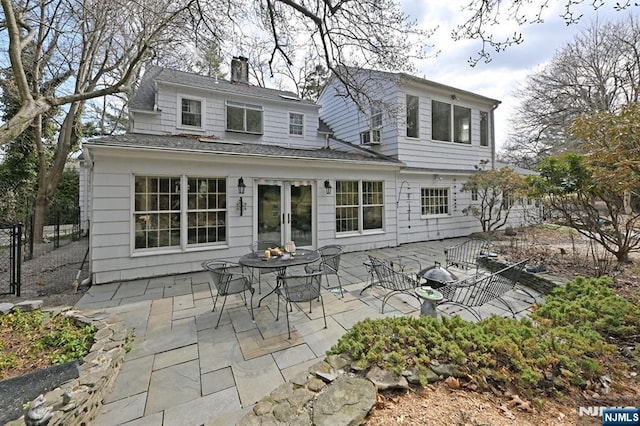 back of house with a patio area, french doors, a chimney, and fence