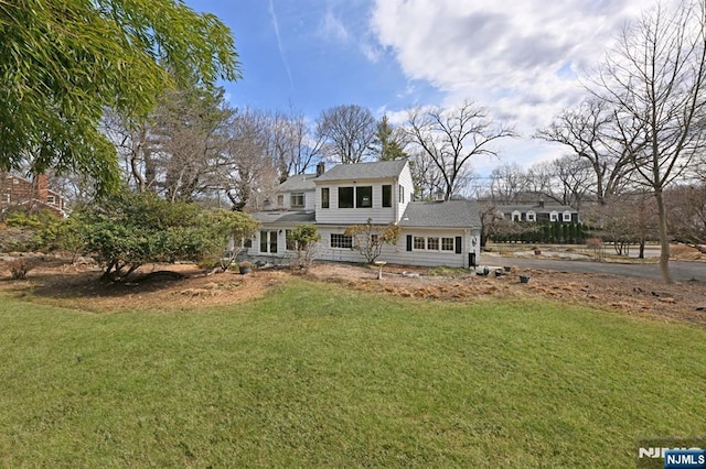 view of front of property featuring a front yard and a chimney