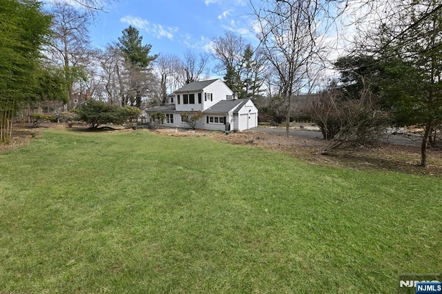 view of yard with an attached garage and driveway