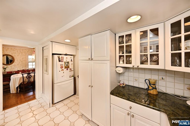 kitchen featuring glass insert cabinets, white cabinets, freestanding refrigerator, and light floors