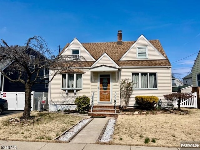 view of front of property with a shingled roof, fence, and a chimney