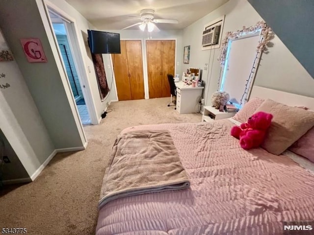 bedroom featuring two closets, a ceiling fan, a wall mounted AC, carpet, and baseboards