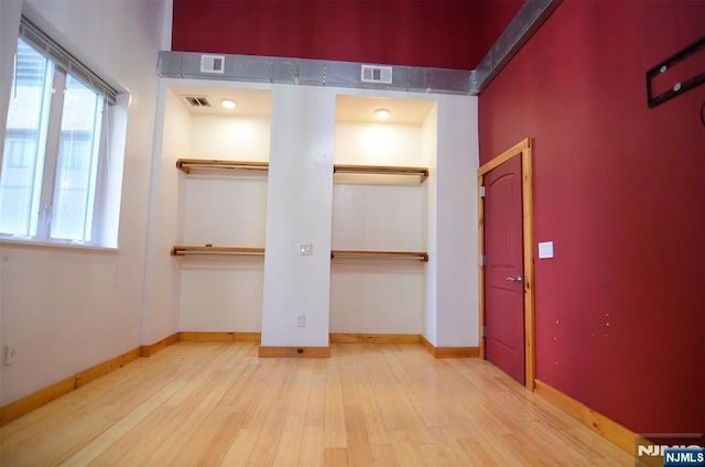 75 Liberty Ave Unit B23, Jersey City, NJ 07306 - unfurnished bedroom featuring multiple windows, wood finished floors, visible vents, and two closets