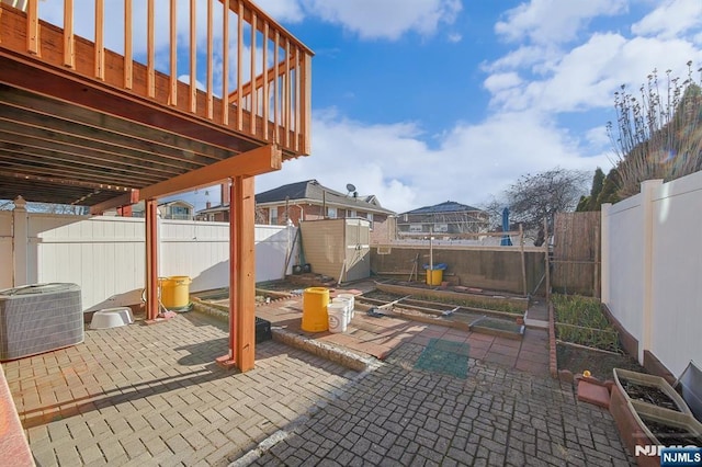 view of patio / terrace featuring an outbuilding, cooling unit, a storage shed, and a fenced backyard