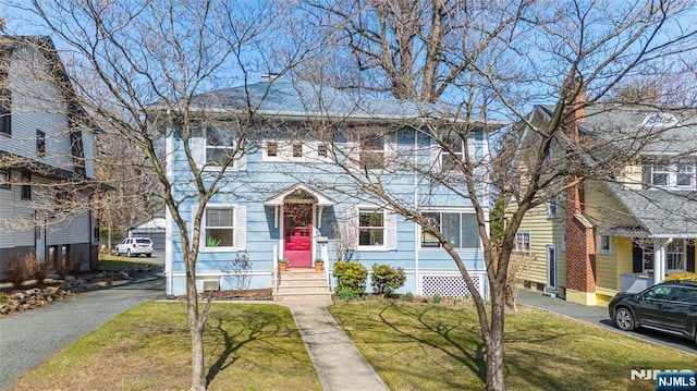 colonial inspired home with a front lawn