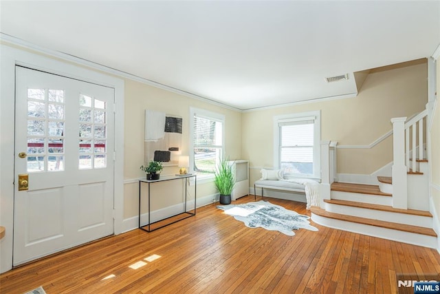 entrance foyer with visible vents, stairs, baseboards, and hardwood / wood-style floors