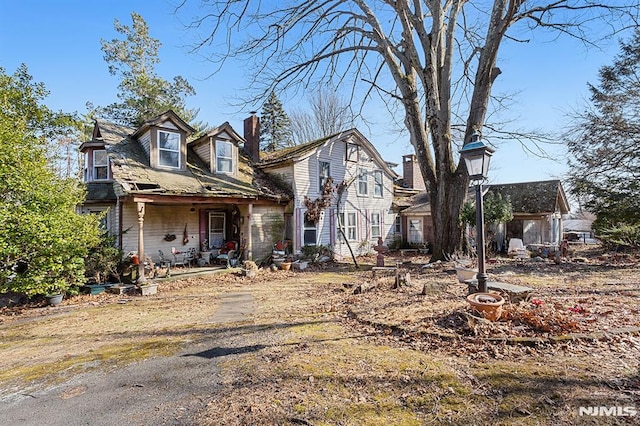 view of front of property featuring a porch and a chimney