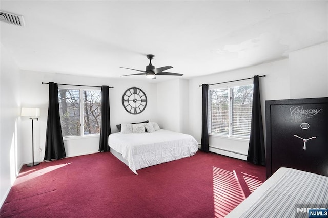 carpeted bedroom with baseboards, visible vents, baseboard heating, and ceiling fan