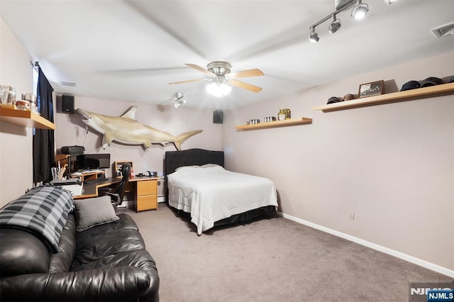 bedroom featuring rail lighting, light colored carpet, visible vents, and baseboards