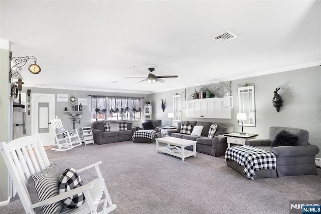 living area with visible vents, carpet flooring, ceiling fan, and ornamental molding