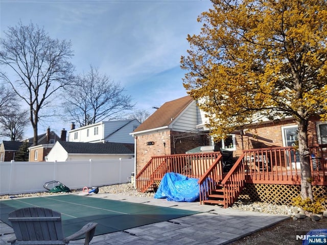 exterior space with a wooden deck, a fenced in pool, and fence