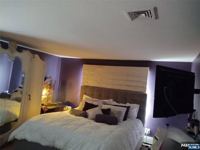 bedroom featuring visible vents and a baseboard radiator