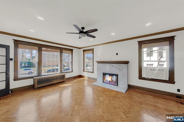 unfurnished living room with radiator heating unit, a healthy amount of sunlight, and baseboards