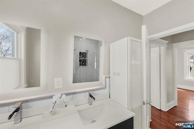 full bathroom featuring vanity, wood finished floors, and baseboards