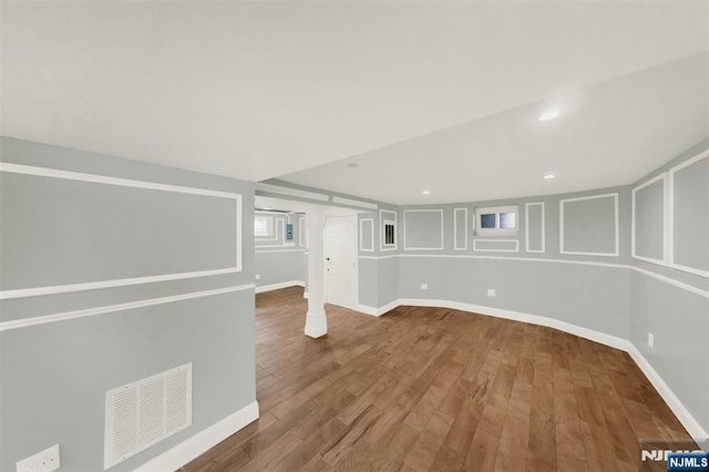 finished below grade area featuring visible vents, recessed lighting, baseboards, and wood finished floors